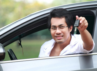man in car holding keys outside window 
